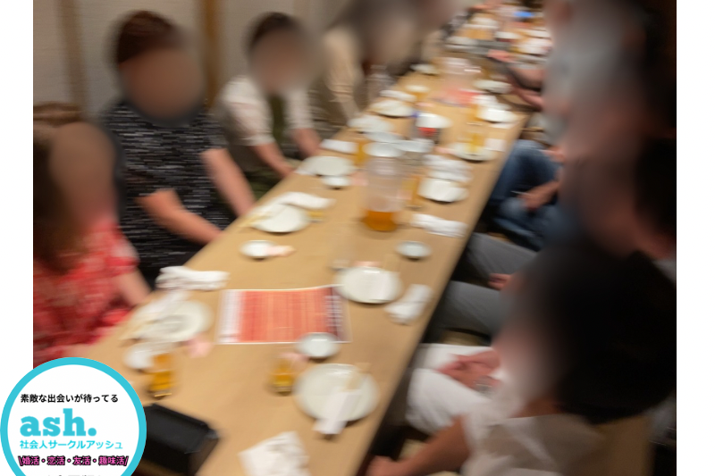 イベント会場でスタッフが参加者を笑顔で案内し、初参加でも安心して交流できる雰囲気が伝わる