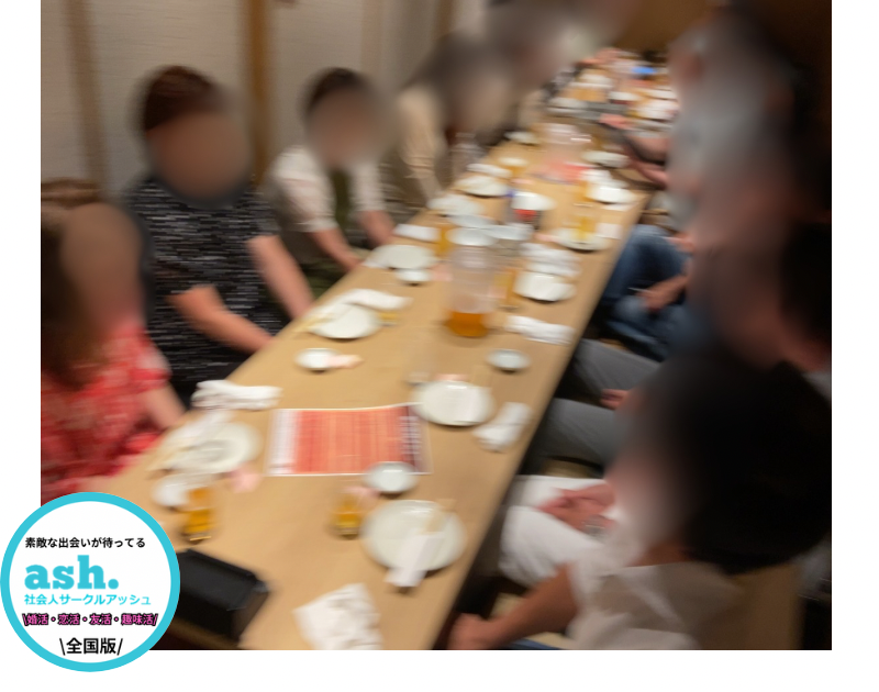 イベント会場でスタッフが参加者を笑顔で案内し、初参加でも安心して交流できる雰囲気が伝わる