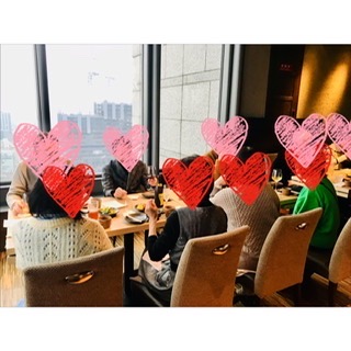 岡山駅周辺の落ち着いた飲食店で、40代 50代の日本人男女が笑顔で会話を楽しむ社会人サークルの交流会