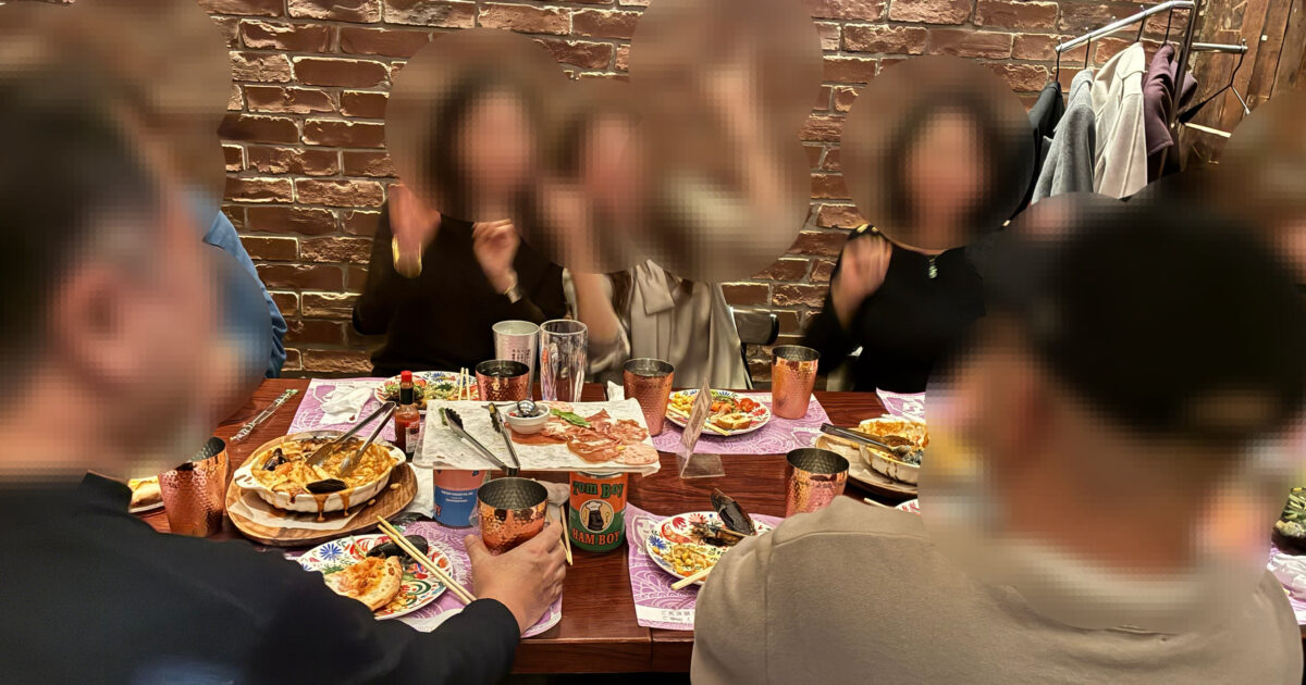 新宿の落ち着いたレストランで、45才から59才の男女が笑顔で交流している少人数食事会のイメージ