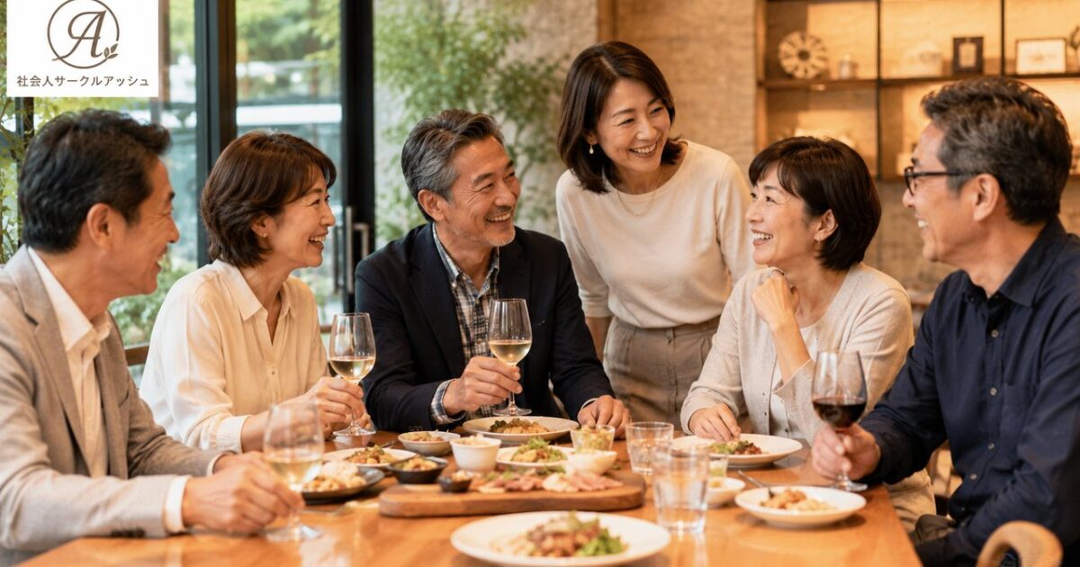 広島の落ち着いたレストランでカジュアルな服装の50代日本人男女6名が食事を囲み、笑顔で交流する社会人サークルアッシュの食事会